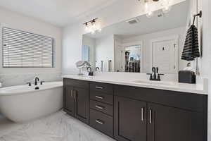 Bathroom with vanity, a tub, and a textured ceiling