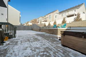 Snowy yard featuring a hot tub