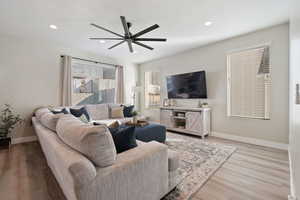 Living room featuring ceiling fan and light wood-type flooring