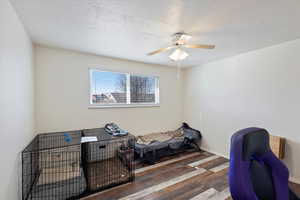 Bedroom 1 with wood-type flooring, ceiling fan, and a textured ceiling