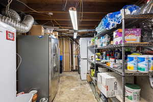 Basement with stainless steel fridge with ice dispenser