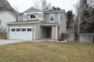 View of front of property with a garage and a front lawn