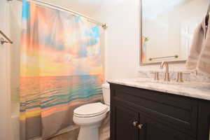 Full bathroom with vanity, tile patterned floors, toilet, and shower / bath combo