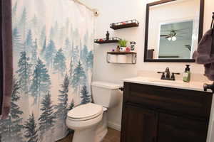 Bathroom featuring vanity, ceiling fan, tile patterned floors, and toilet