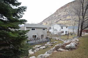 Rear view of house featuring a yard and a deck with mountain view