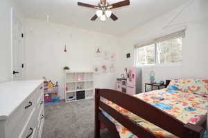 Carpeted bedroom featuring ceiling fan