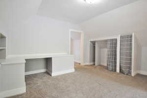 Living room with vaulted ceiling and light carpet