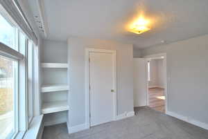 Bedroom featuring carpet, a closet, and built in bookshelves.