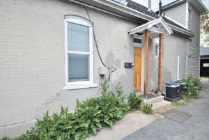 Doorway to the upstairs unit.  The property features separate central air condition unit.  Please note the USPS has this unit as 26 S 300 E Logan.