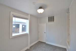 Bedroom featuring carpet floors and access to the laundry room.