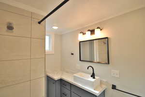 Bathroom featuring crown molding and vanity