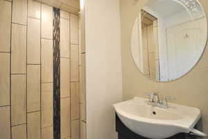 Bathroom featuring vanity and updated shower.