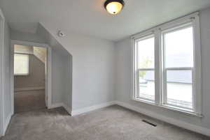 Upstairs nook with light carpet and plenty of natural light at the top of the stairs.