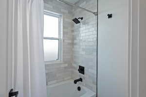 Bathroom featuring shower / bathtub combination with curtain