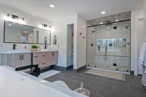 Bathroom with walk in shower, vanity, tile patterned flooring, and decorative backsplash