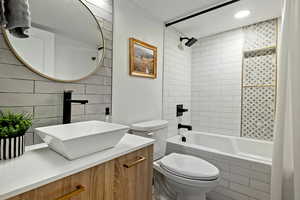 Full bathroom featuring vanity, tasteful backsplash, toilet, and shower / bath combo with shower curtain