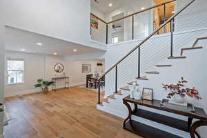 Staircase featuring hardwood / wood-style flooring, a towering ceiling, and ceiling fan