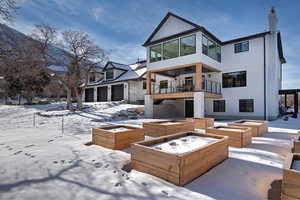 Snow covered rear of property with a balcony