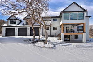 View of back of property featuring a garage and a balcony