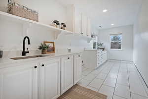 Kitchen featuring white cabinetry, sink, and light tile patterned floors