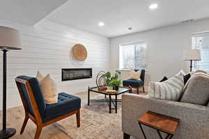 Living room with light hardwood / wood-style flooring and wood walls