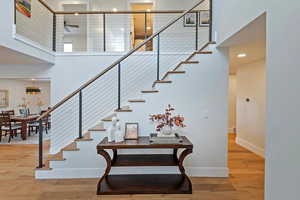 Entry with hardwood / wood-style floors, a towering ceiling, and ceiling fan