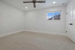 Empty room with light carpet and ceiling fan