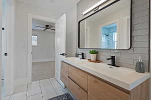 Bathroom featuring tasteful backsplash, vanity, tile patterned floors, and ceiling fan