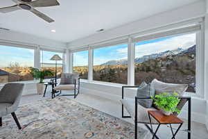 Sunroom / solarium featuring a mountain view, plenty of natural light, and ceiling fan