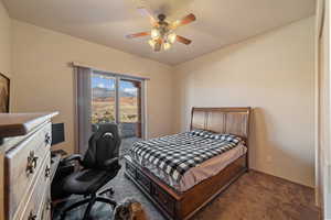 Bedroom with dark colored carpet, access to outside, and ceiling fan