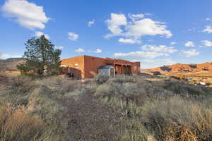 Rear view of property with a mountain view and a storage shed