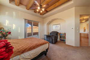 Bedroom with ceiling fan, carpet floors, access to outside, and beam ceiling