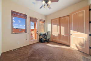 Interior space featuring ceiling fan and carpet floors