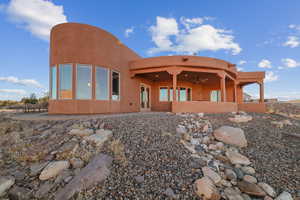 Rear view of house featuring ceiling fan