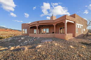 Back of property featuring ceiling fan and a mountain view