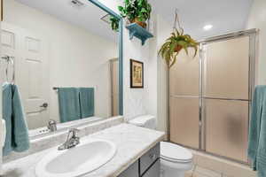 Bathroom with tile patterned flooring, vanity, toilet, and walk in shower