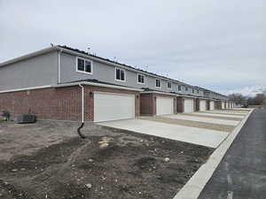 View of property exterior with a garage and central air condition unit