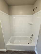 Bathroom featuring wood-type flooring, a textured ceiling, and shower / bath combination