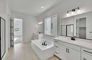 Bathroom featuring tile patterned floors, vanity, and plus walk in shower