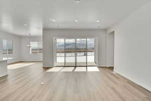 Interior space with a notable chandelier, a textured ceiling, and light wood-type flooring