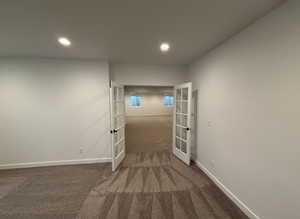 Corridor with dark carpet and french doors