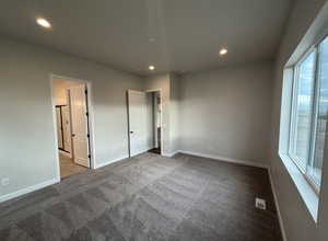 Unfurnished bedroom featuring carpet flooring and multiple windows