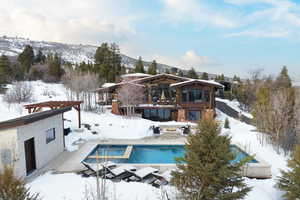 Snow covered house featuring a mountain view