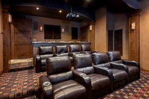 Carpeted home theater with ornate columns