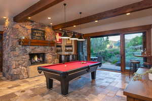 Recreation room with a fireplace, billiards, and beamed ceiling