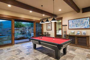 Game room with beamed ceiling and billiards