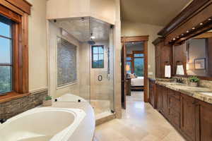 Bathroom featuring vanity, lofted ceiling, and plus walk in shower