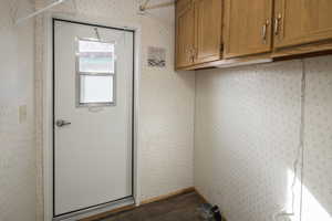 Laundry room with dark wood-type flooring