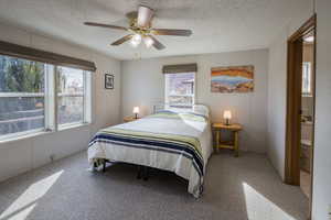 Bedroom with ceiling fan and a textured ceiling