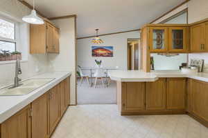 Kitchen featuring crown molding, sink, pendant lighting, and kitchen peninsula